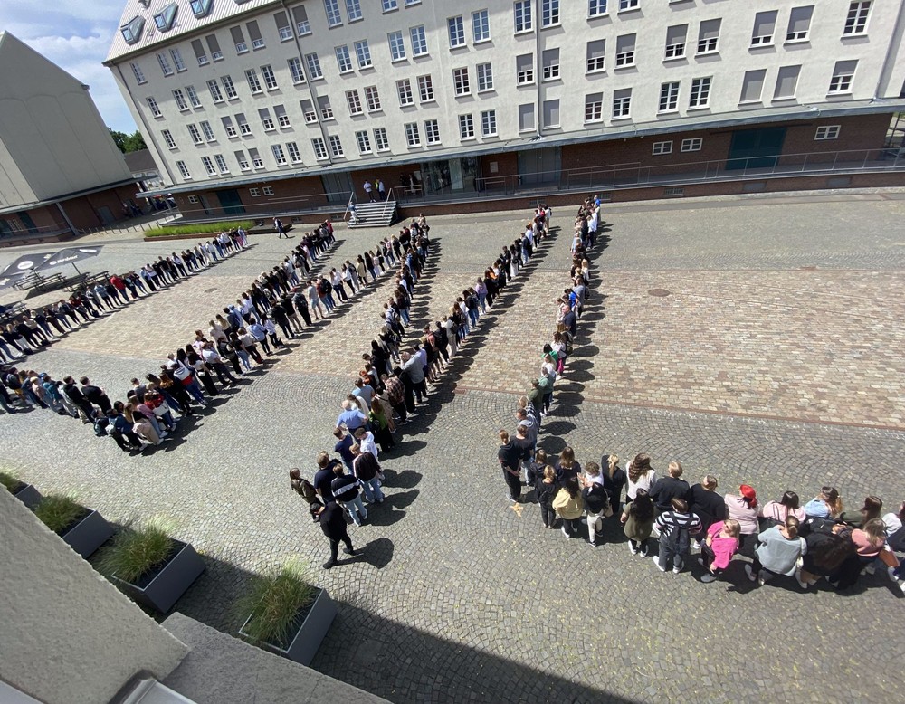 Viele Menschen formen auf einem Hof den Schriftzug "LWL". (Bild: LWL/Hekel)